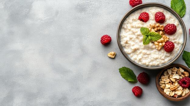 Top view of oatmeal with raspberries and nuts on a gray background photo