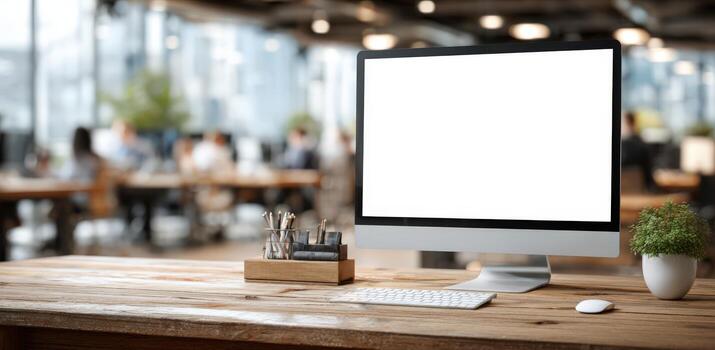 Modern workspace featuring a sleek computer monitor with blank screen, wooden desk, stationery holder, and greenery, creating an inviting atmosphere for productivity and creativity photo