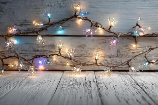 Colorful string lights with glowing bulbs are elegantly draped over rustic wooden planks, creating a warm and inviting atmosphere for festive celebrations and cozy gatherings photo