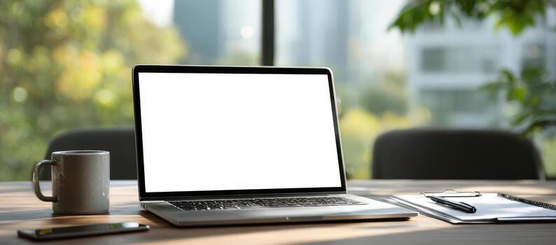 Laptop mock up with blank screen on wooden desk, surrounded by coffee cup, notebook, and pen, showcasing a modern workspace with natural light and greenery photo