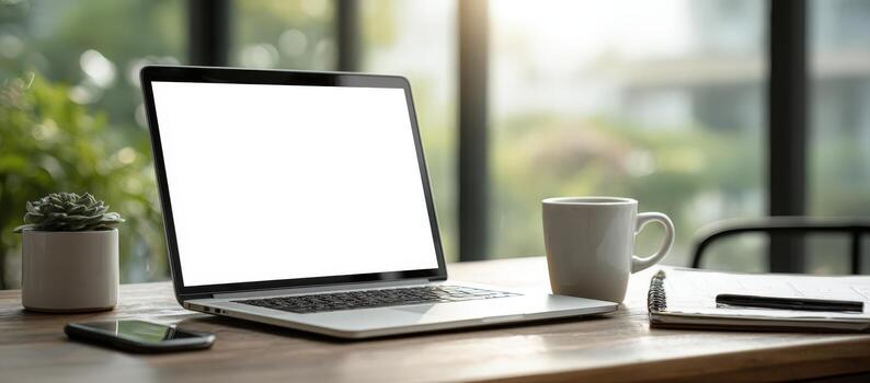 Laptop mock up with blank screen on wooden desk, surrounded by coffee cup, smartphone, notebook, and succulent plant, creating a modern workspace atmosphere photo