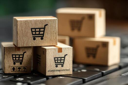 Stacked wooden boxes with shopping cart icons are placed on a keyboard, symbolizing online shopping and e-commerce, showcasing the intersection of technology and retail photo