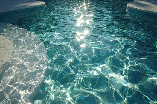 Crystal-clear swimming pool water reflecting sunlight, with rippling surface patterns and smooth stone edges, creating a serene and inviting atmosphere for relaxation and leisure photo