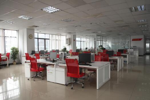 Modern office interior featuring spacious layout with bright natural light, sleek white desks, and vibrant red chairs, creating an inviting and productive work environment photo