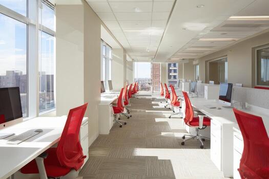 Modern office interior featuring bright, spacious layout with white desks and red chairs, showcasing a collaborative workspace with natural light and contemporary design elements photo