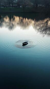A boat floating in a lake with a ripple pattern photo