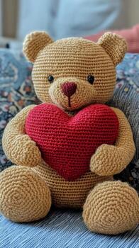 bear holds red heart while sitting against dark wooden backdrop in cozy setting. photo