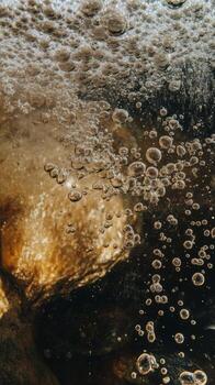 Bubbles rising in a dark liquid create a captivating underwater effect. photo