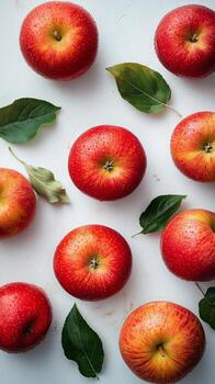 Fresh Red Apples Arranged With Green Leaves on a White Background Showcasing Vibrant Colors and Textures photo