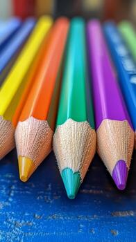 Colorful Pencils Arranged Neatly on a Blue Surface Showing Bright Tips photo