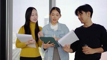 ung asiatisk börja kreativ design team i en brainstorming session i en coworking Plats. de fokus på utvecklande kreativ aning för branding projekt, visa upp lagarbete och professionell tillväxt. video