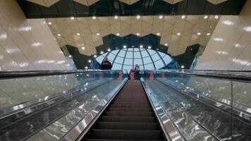 Commuters move up and down escalators at a bustling subway station, showcasing public transportation dynamics in a vibrant urban environment during busy hours. video
