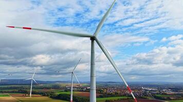 vind turbiner generera rena energi mot en omfattande landskap visa upp fält och avlägsen kullar under en dynamisk himmel video