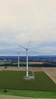 turbines on the background of large fields. Aerial view of wind turbines and agricultural fields. Wind turbines generate electricity, green energy video