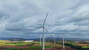 mulino a vento contro un' nuvoloso cielo. vento turbine nel un' campo contro un' sfondo di autunno alberi. video