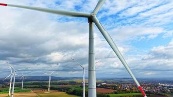 mulino a vento avvicinamento contro un' nuvoloso cielo. vento turbine nel un' campo contro un' sfondo di autunno alberi. video