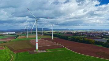 mulino a vento campo contro il sfondo di un autunno foresta. arancia alberi su un' campo con mulini a vento. vento turbine su un' campo nel il campagna nel Europa. energia generazione di mulini a vento. video