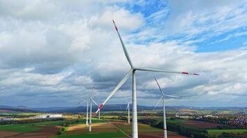 vento turbine nel un' campo contro un' sfondo di autunno alberi. video