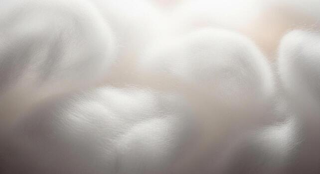 A close-up of a bunch of soft white cotton wool, illuminated by a warm light, creating a peaceful and delicate texture, suitable for medical or wellness concepts. photo