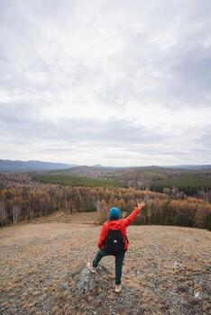 Trail blazed through dense woods, Hiker points out clear footpath below trees, Wilderness explorer confidently navigates extensive forested landscape using visual guides and signals photo