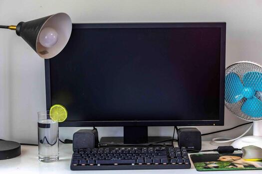 A comfortable, organized, clean, and minimalist work and study desk, with a computer, monitor, keyboard, mouse, and lamp. photo