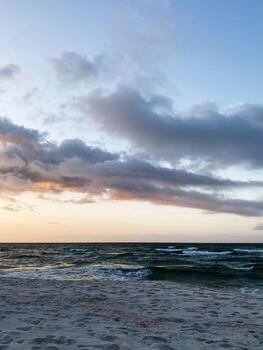 Sunset over a calm Florida Pensacola beach with gentle waves, soft clouds, and tranquil horizon photo
