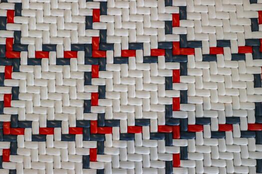 Close up abstract texture of woven plastic straps in a white red and blue checkered pattern Detailed geometric background ideal for digital texture overlay or textile concepts photo