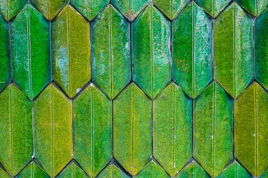 Abstract vertical background texture of glossy ceramic tiles in a green to yellow gradient arranged in a herringbone or fish scale pattern Typical of Thai temple architecture photo