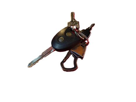 un de cerca ver de un llavero con un coche llave remoto y varios metálico llaves aislado en un blanco antecedentes foto