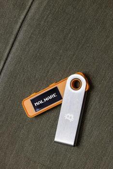 hardware Bitcoin wallet with Malware message on screen laying on fabric background photo