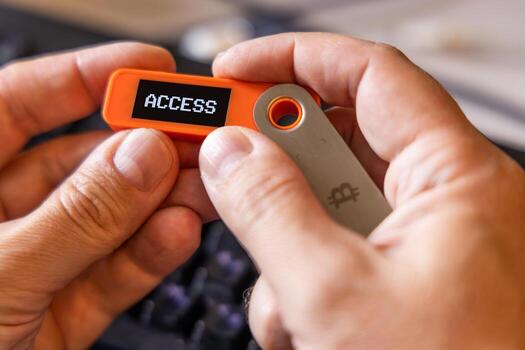 Access message on screen of orange hardware Bitcoin wallet in hands photo