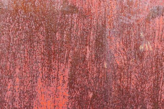 Worn red painted surface with scratches and discoloration, showing signs of age and use - Full-frame background and texture. photo