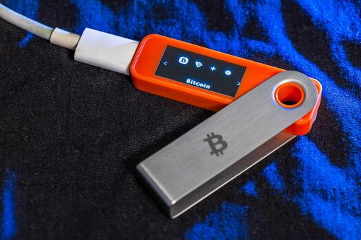 Hardware wallet displaying Bitcoin account on fabric background. photo