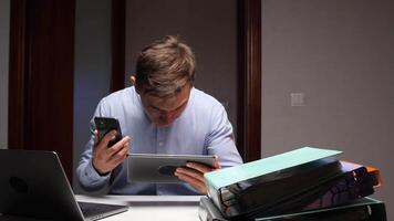 zakenman multitasking met meerdere apparaten ervaren informatie overbelasten video