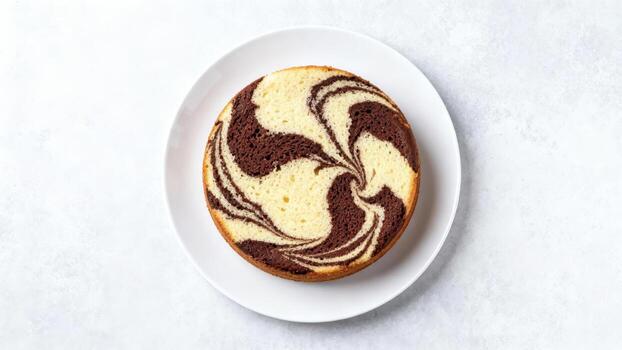Sliced marble cake with striking swirl pattern rests on a white ceramic plate above a light surface photo