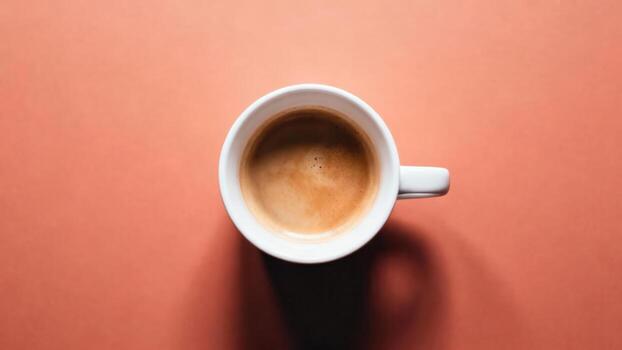 Overhead view captures freshly brewed beverage in ceramic container resting on uniform surface photo