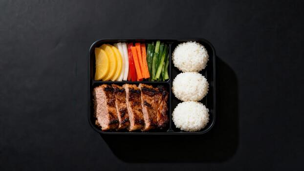 Grilled seasoned meat and rice served with colorful pickled vegetables inside a black partitioned container photo