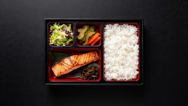 A la parrilla salmón filete y clasificado lado platos presentado en un dividido envase en contra un oscuro antecedentes. foto