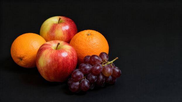 Assortment of fresh, ripe apples, oranges, and grapes arranged on a dark background photo