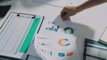 un' persona è puntamento a un' documento con grafici e documenti video
