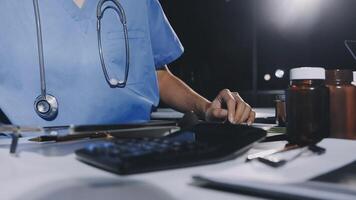 A doctor is working on a computer with a calculator video