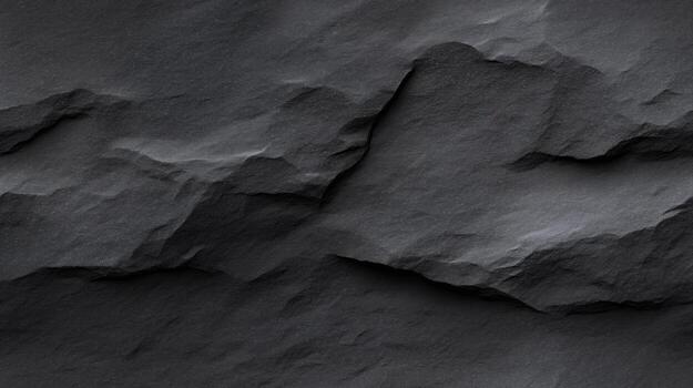 A detailed close-up view of textured dark gray stone, showcasing its rugged surface and varied patterns. photo