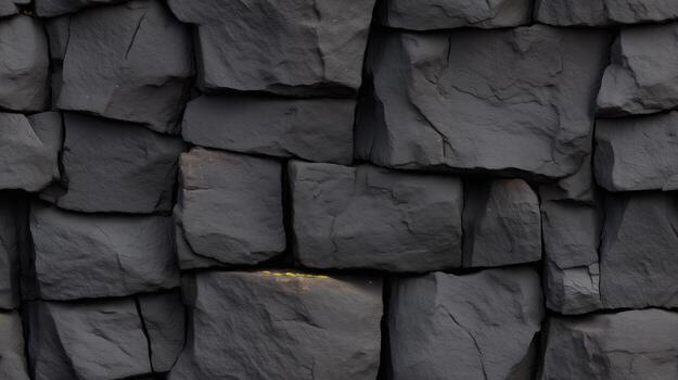 Close-up view of a dark gray stone wall with irregular, interlocking blocks. A textured, robust stonework construction showcases the natural shapes and patterns of the building material. photo