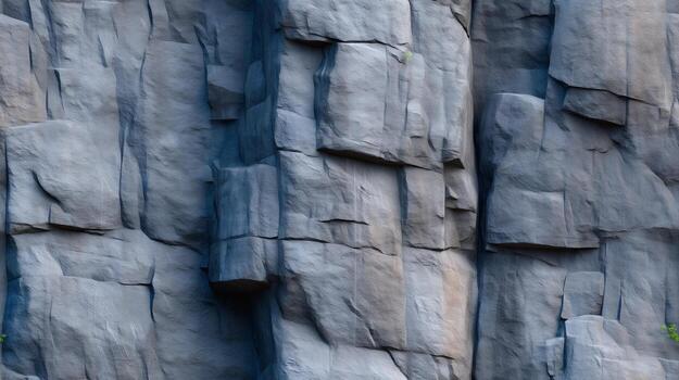 A close-up view of a textured rock face, showcasing the rough, angular shapes and varied shades of gray. photo