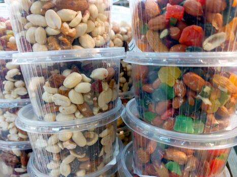 Assorted Nuts and Fruits Displayed in Clear Plastic Containers at a Market photo