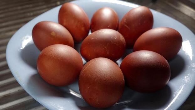 Plate holding painted red Easter eggs with textured eggshell placed on table photo