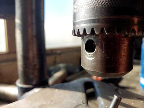 Close View of Drilling Machine Chuck During Metalworking Process in Workshop Setting photo