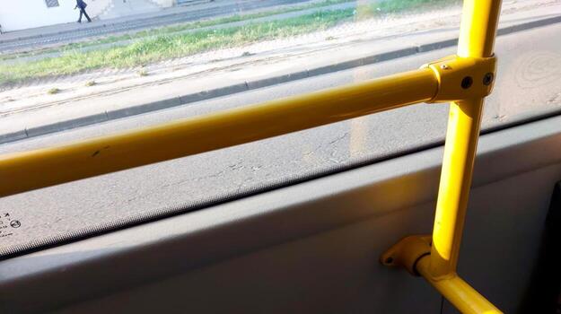 Handrails Inside a Public Bus With View of the Street and Passerby photo