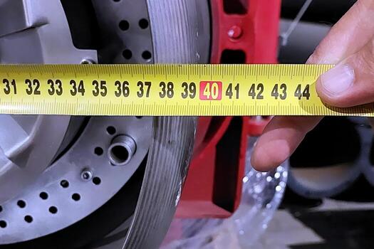 A person measuring the size of a tire with a measuring tape photo