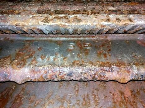 Melted Burner Grates Reveal Signs of Wear and Tear From Extensive Use in Kitchen Setting photo